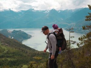 Adulte portant un bébé à la montagne